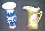 Duas peças de porcelana, sendo: pequeno vaso chines azul e branco (13 cm) e pequena jarra alemã decorada com rosas (12 cm)