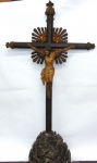 Crucifixo com Cristo em madeira policromada, cruz com tres ponteiras e quatro resplendores em madeira, base esculpida e policromada. Medidas Cruz 89 x 23 x 15 cm. Cristo 30 x 26 cm.
