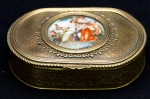 Caixa porta jóias em metal dourado com vermeil, francesa, ricamente trabalhado, com placa de porcelana com pintura de Ninfas, parte interna forrada de veludo. Medidas 3 x 10 x 7,5 cm