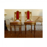 Par de pequenas cadeiras em estilo francês, em madeira dourada, estofadas em veludo vermelho