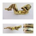 OXANA. escultura em bronze dourado representando Mulher deitada. Galeria Irlandini, 1979. Assinada. Medidas 24 x 39 cm