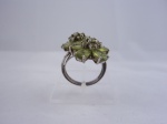 Anel de prata contrastada 925 ml. com pedras verdes, montagem em formato de flor. Aro 18 - Peso total: 6,5 g.