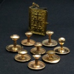 Lote de peças em metal dourado , sendo: 1 mini livro religioso e 8 abotoaduras.