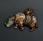 Bijuteria de luxo, origem USA. Broche de metal na coloração "ouro vermelho" e pedrarias representando um rinoceronte.