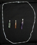 Três pendentes, sendo ametista, esmeralda e topázio imperial. Um cordão em prata
