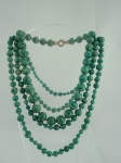 Semi-jóia - Lote composto de gargantilha medindo 48cm, com pedras em formato esférico na cor verde e fecho de prata e de um colar, medindo 134cm.
