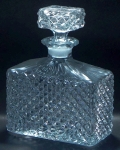 Perfumeiro,19cm, grosso cristal prensado incolor, corpo em paralelogramo, e, como o tampo, ornamentado em relevo no padrão dito "bico de jaca". Margem do gargalo facetada. Muito bem conservado.
