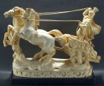 Grupo escultórico, artesania contemporânea, 20x25x10cm; artesania contemporânea, estuque: soldado romano, em sua biga; a parelha de equinos empinada, vigoroso movimento. Bem conservado.