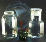 Objetos em vidro, contemporâneos, bem conservados: castiçal verde, travessa com pegas e 2 potes; o maior, 27cm.