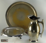 Metal espessurado à prata, manufaturas nacionais: travessa circular, 30cm; salva com 3 pés (manufatura Rebouças), 20cm, e jarra, 22cm.