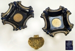 Par de cinzeiros, 3,5x15x15cm, contemporâneos, porcelana alemã, marcas da manufatura na base, decorados em azul e dourado, quadrados, faces e ângulos recurvados. Incluso pequeno cinzeiro em bronze dourado. Muito bem conservados.