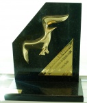 Escultura em bronze dourado aplicada sobre mármore negro representando Gaivota - Prêmio Mercado de Seguros - Melhor Seguradora em Seguro Saúde 2001, med. 26 x 22 x 10 cm. Estado de conservação bom