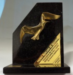 Escultura em bronze dourado aplicada sobre mármore negro representando Gaivota - Prêmio Mercado de Seguros - Excelência em Capitalização Produto Super Facil Carro 2003", med. 26 x 22 x 10 cm. Estado de conservação bom