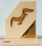 Escultura em bronze dourado sobre mármore branco "Troféu Gaivota de Ouro" Prêmio Mercado de Seguros 2009 - Sulacap, med. 27 x 22 x 10 cm. Estado de conservação bom