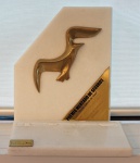 Escultura em bronze dourado sobre mármore branco "Troféu Gaivota de Ouro" Prêmio Mercado de Seguros 2009 - Brasil Saúde Cia de Seguros, med. 27 x 22 x 10 cm. Estado de conservação razoável (descolado)