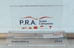 Placa em acrílico "P.R.A. Super Campeões 2014", med. 12 x 20 x 8 cm.  Estado de conservação bom