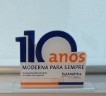 Placa em acrílico "110 Anos - Moderna para sempre", med. 12 x 7 x 4 cm.