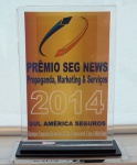 Placa em acrílico "Prêmio SEGNEWS 2014", med. 25 cm. Estado de conservação bom
