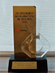 Escultura em acrílico com base em material sintético "Os Melhores do Marketing de Seguros 1993 - FENASEG", med. 20 cm. Estado de conservação razoável