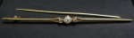 Imponente prendedor de gravata Art-Nouveau em ouro com 3 brilhantes, medida 9,5 cm Peso total 6.6 g ( com estojo do Ourives).