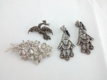Conjunto de bijuterias composto de: par de brincos e dois broches, em metal prateado, com brilho. Peso total 30g.