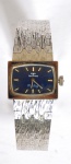 Relógio feminino da marca TCHNOS, mostrador azul, pulseira prateada ( no estado). Acompanha estojo.
