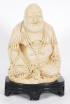 Estatueta em resina representando Buda com peanha. Alt. 19 cm