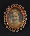 Broche porta retrato em ouro com aplicações em platina e pequenos brilhantes, med. 38 x 30 mm. Peso total 10,5 g.