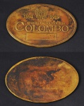 Colecionismo - Confeitaria Colombo, ficha de reserva executada em bronze dourado e polido, medindo 70 x 45 mm, com monograma, data 1894 - 1919 e inscrição Confeitaria Colombo. No verso número 058.