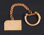 Chaveiro com placa em ouro amarelo com inscrição "Bento 6/1/965", peso total 8,3 gramas, medida da placa 2,5 x 1,5 cm, medida chaveiro 9,5 cm