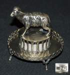 Paliteiro em prata portuguesa , contrastada, decorada com carneiro sob coluna apoiada em pequena salva, medindo 9 cm de altura e 9 cm. de diâmetro. Peso aprox.  195 g.