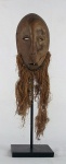 Imponente máscara africana de coleção em madeira entalhada com barba em palha trançada, sobre base em ferro, med. 54 cm