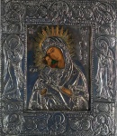 Antigo ícone russo representando Santana Mestra com mãos e faces à mostra, o restante coberto em prata ricamente trabalhada e decorada com motivos religiosos.Medidas 31,5 x 27 cm.