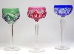 Três taças em cristal lapidado nas cores: rubi, anil e esmeralda.Alts. 20 cm. , 19,5 cm e 19 cm.
