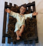 Imagem de Menino Jesus na manjedoura, em estuque policromado (dedinho do pé direito quebrado). Medidas  24 x 20 cm.