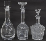 Lote contendo três garrafas em cristal lapidado( 1 lapidação dedão tampa lascada), medindo 26 cm , 31 cm. e 32 cm.