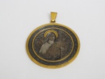 Imponente medalha em metal amarelo e figura de "Sta Thereza de L'enfant Jesus" em alto relevo em prata. Possui alça. Peça assinada por B.Wicker - GR, gravador ; inscrições no verso .