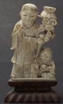 Grupo escultórico  em marfim representando Homem com criança(pequeno quebrado|) . Acompanha peanha de madeira. Alt. total 10 cm.