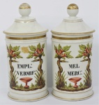Par de potes de farmácia em porcelana francesa , com nomes das substâncias "EMPL:VERMIF:" e "MEL MERC: ". Século XIX. Alt. 26 cm