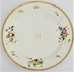 Prato em porcelana com bordas à ouro e flores, tendo coroa e iniciais da família "Visconde de Merity". Com restauro. Diâm. 23 cm