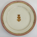 Prato em porcelana francesa do século XIX, marca CH. PILLIVUYT, esmaltado com policromia rosa e realçada à ouro, no centro Monograma do titular coroado. Diâm. 21 cm.