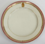 Prato em porcelana francesa do século XIX, esmaltado com policromia rosa realçada à ouro, ostentando brasão de "Barão de São Thiago". Diâm. 23 cm.