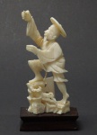 Pequena estatueta em marfim representando Pescador com base em madeira , medindo 8 cm.