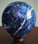 Grande esfera em mármore rajado na cor azul, base de madeira, diâmetro 20 cm.