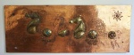 Quadro decorativo em folha de cobre e metal dourado, medindo 57x150 cm
