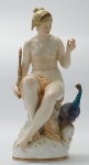 Grupo escultórico em porcelana KPM , representando figura feminina com pavão (dedos da mão e pé quebrado), medindo 20 cm de altura.