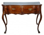 Excepcional mesa estilo Dom José I, em jacarandá louro entalhado,  com 2 gavetas filetadas e com  puxadores de bronze, saia recortada e entalhada. Medidas 81 x 112 x 52 cm.