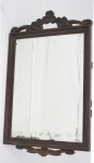 Espelho bizotado com moldura em madeira entalhada. Medidas  84 x 53 cm.