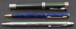 Lote contendo três canetas , sendo: 1 marca HARLEY DAVIDSON, cinza e prateada, 1 lapiseira KANOE, esmaltada em azul e 1 CROSS caneta.