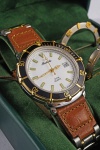 Relógio Michéle, caixa em aço com detalhes em dourado 37mm, pulseira em couro marrom com aço, em perfeito estado, na caixa com acessórios extras.